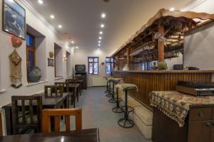 a restaurant with tables and chairs and a bar at Kapadokya Stonelake Hotel in Guzelyurt