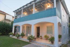 a white house with a balcony on top of it at Tsonas Apartments in Lygia