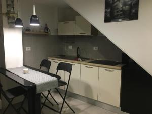 una cucina con tavolo e sedie e una cucina sotto una scala di PORTO 48 a Bari