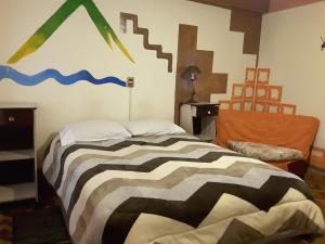 a bedroom with a bed with a painting on the wall at Hostal La Casa del Sol in Copacabana