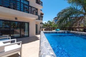 una piscina di fronte a una casa di Aldea Thai Beachfront Condo Complex with Resort Pool & Amenities a Playa del Carmen