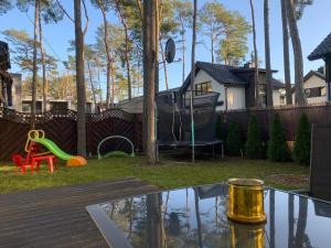 a backyard with a table and a playground at Villa Kris in Pobierowo