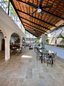 a lobby with tables and chairs and a ceiling at Casa del Sol Inn in Ajijic