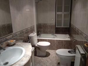 a bathroom with a toilet and a sink and a tub at Apartamento Ayub in Calatayud