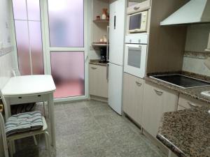 a kitchen with white appliances and a table in it at Apartamento Ayub in Calatayud +2 photos
