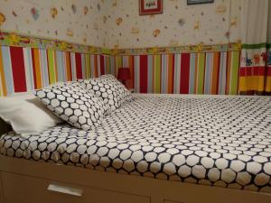 a bedroom with a white bed with a colorful wall at Apartamento Ayub in Calatayud