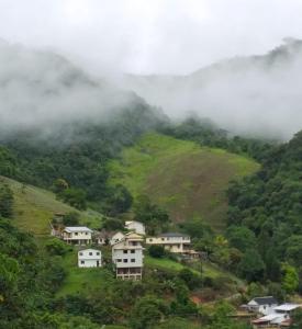 eine Gruppe von Häusern auf einem Hügel in den Wolken in der Unterkunft Cobertura das Montanhas in Domingos Martins