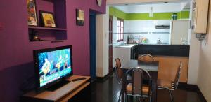 a living room with a television on a table with a kitchen at La Francisca in San Salvador de Jujuy