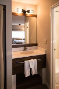 a bathroom with a sink and a mirror and towels at Basecamp Boulder in Boulder