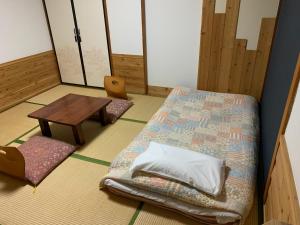 a room with a bed and a wooden table at Turtle Inn Nikko in Nikko