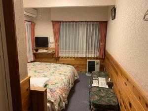 a hotel room with two beds and a television at Turtle Inn Nikko in Nikko