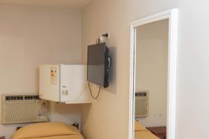 a small room with a microwave and a mirror at Hotel Garden in San Miguel de Tucumán