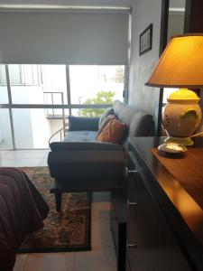 un soggiorno con divano e tavolo con lampada di Residence Las Trojes Cdmx a Città del Messico