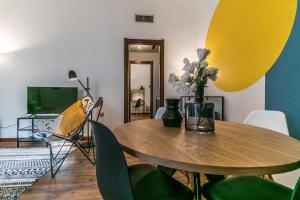 uma sala de jantar com uma mesa de madeira e cadeiras verdes em Design Apartments Sassari-Torre Tonda em Sassari
