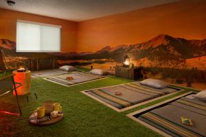 ボルダーにあるBasecamp Boulderのベッド4台が備わる客室で、壁には山の壁画が施されています。