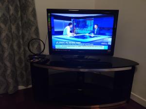 uma televisão de ecrã plano em cima de uma mesa em Appartement tout équipé au calme - RefKL em Montfermeil