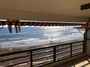 a view of the beach from a balcony at Espectacular en primera línea de la playa in Telde