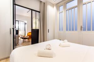 een slaapkamer met een wit bed en 2 handdoeken bij Dreamyflat - caire ll in Parijs