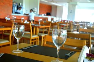 two wine glasses sitting on a table in a restaurant at Salinas Park Resort in Salinópolis