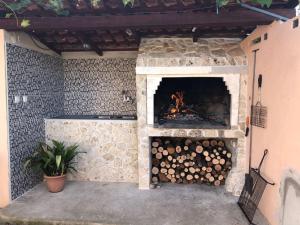 a stone fireplace with a fire in it at Apartments Ružica - 50m from the sea in Lukoran