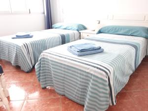 zwei Betten mit Handtüchern in einem Zimmer in der Unterkunft Yumbo - Apartment in Playa del Ingles