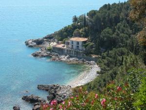 a house on a hill next to the water at Hotel Conca d'Oro in Stalettì