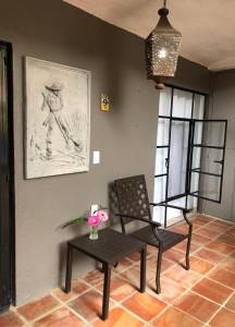 a room with a chair and a table and a picture at Casa del Sol Inn in Ajijic