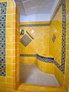 Baño de azulejos amarillos con bañera. en Casa del Sol Inn en Ajijic