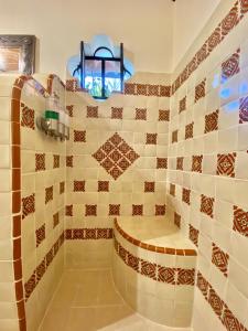 a bathroom with a shower with tiled walls at Casa del Sol Inn in Ajijic