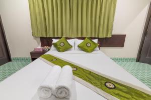 清莱JJ hut hotel的酒店房间里有一张床，上面放着毛巾