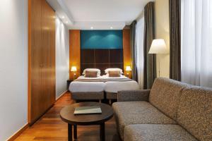 ストラスブールにあるベスト ウエスタン プラス モノポール メトロポールのベッドとソファ付きのホテルルーム