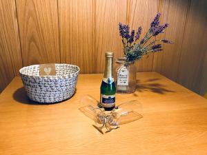 a bottle of champagne and glasses on a wooden table at Wohnung an der Skiwiese - Boxspring - Balkon - 2 Smart TV - Carport in Braunlage +8 photos
