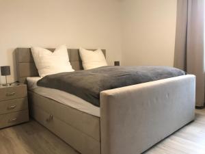 um quarto com uma cama grande e almofadas brancas em Wohnung an der Skiwiese - Boxspring - Balkon - 2 Smart TV - Carport em Braunlage