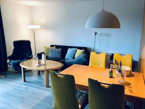 uma sala de estar com uma mesa e um sofá em Wohnung an der Skiwiese - Boxspring - Balkon - 2 Smart TV - Carport em Braunlage