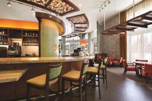 a bar in a restaurant with chairs and tables at Hyatt Place Riverside Downtown in Riverside