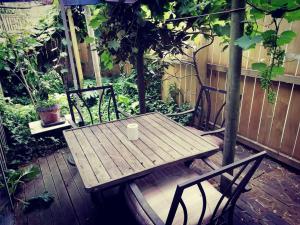 una mesa de madera y sillas en un patio en Pryor Haven Chalet Green Retreat in a Lovely Place en Christchurch