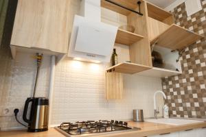 a kitchen with a stove top and a sink at Роскошные апартаменты RentHome в центре in Kemerovo