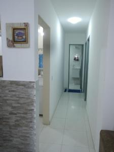 a hallway with white walls and a tile floor at Residêncial primavera in Recife