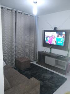 a living room with a television and a couch at Residêncial primavera in Recife