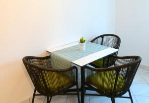 stół z 3 krzesłami i roślina na nim w obiekcie Apartments Gašpar w Crikvenicy