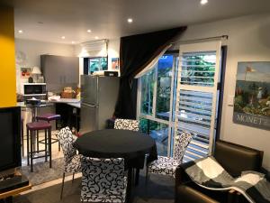 a kitchen with a table and chairs and a counter at Pryor Haven Chalet Green Retreat in a Lovely Place in Christchurch