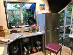 a kitchen with a stainless steel refrigerator at Pryor Haven Chalet Green Retreat in a Lovely Place in Christchurch