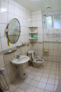 a bathroom with a toilet and a sink and a mirror at Cuiti B&B in Fenchihu