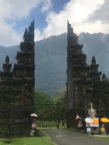 two towers with umbrellas in front of a mountain at New Danas Canggu Guest House in Kerobokan