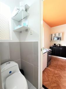 een badkamer met een wit toilet en een keuken bij Lima Real Aparts in Lima