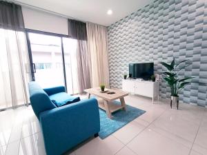 a living room with a blue couch and a tv at Plaza Arkadia Desa Parkcity by KLhomesweet in Kuala Lumpur