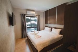 um quarto com uma cama com um bicho de peluche em The Y Smart Hotel em Chiang Mai