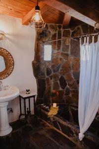 a bathroom with a stone shower curtain and a sink at Korakia Pensione in Palm Springs