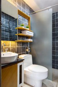 a bathroom with a white toilet and a sink at YATS Colony in Yogyakarta