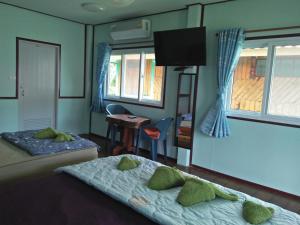 a room with two beds and a desk and window at Happy Days Resort in Ko Mak
